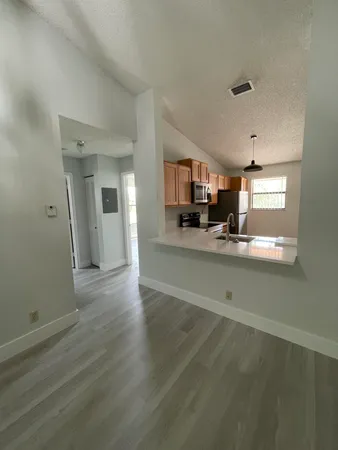 a view of a kitchen center island wooden floor and living room