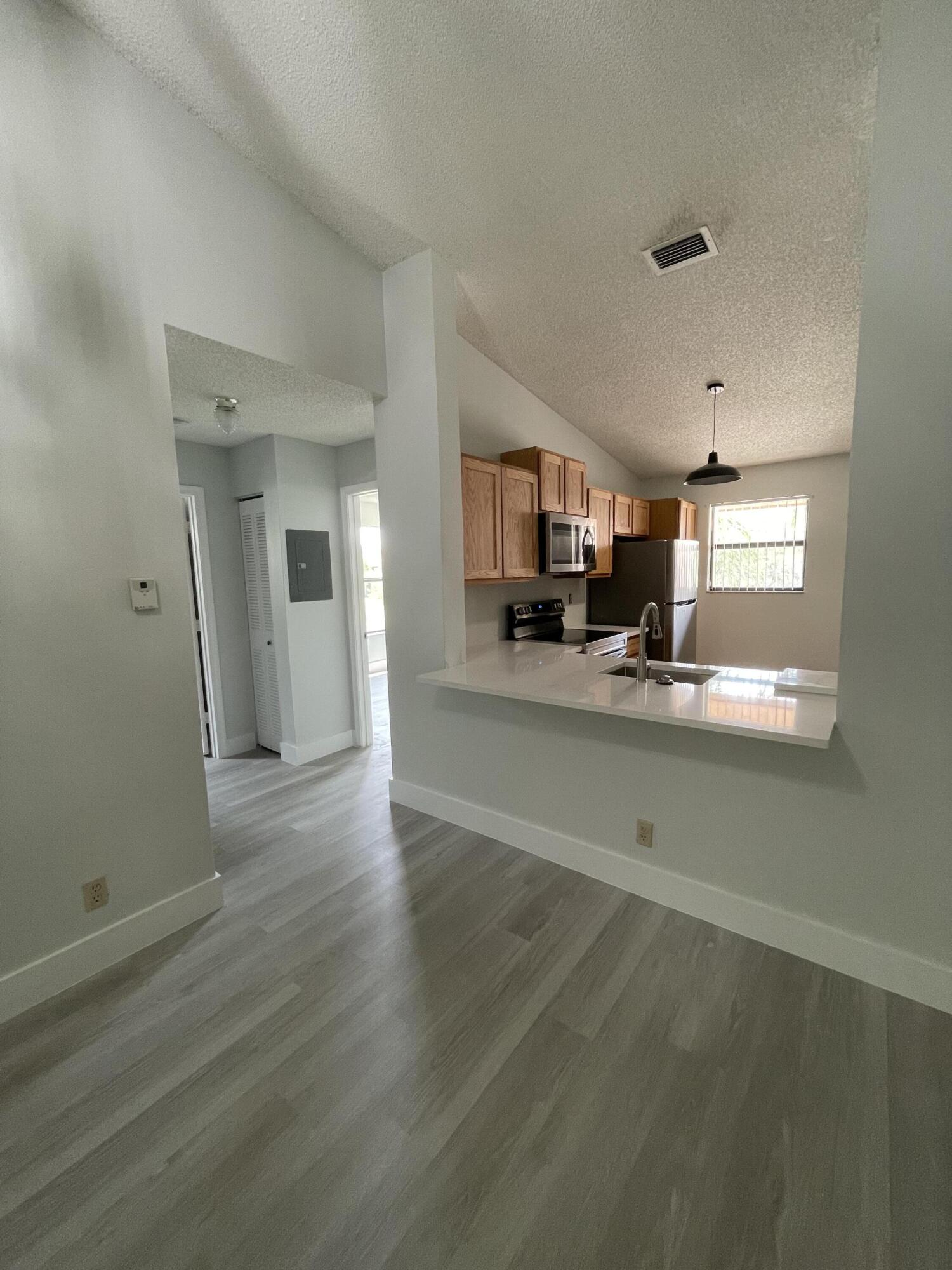 a view of a kitchen center island wooden floor and living room