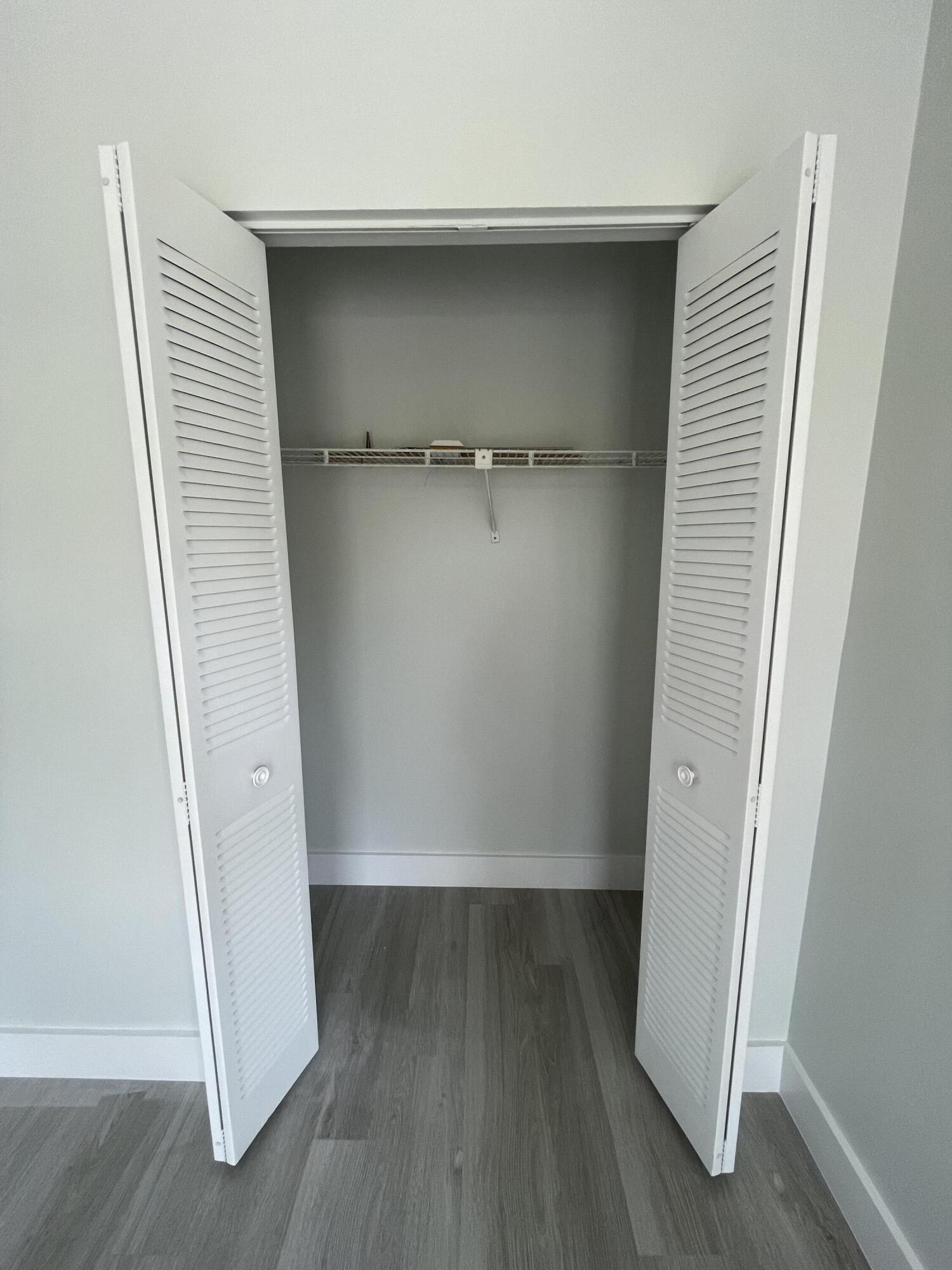 3350 Jaywood Terrace, Unit J221 Boca Raton, FL 33431 - Photo 18 of 31 an empty room with wooden floor and closet