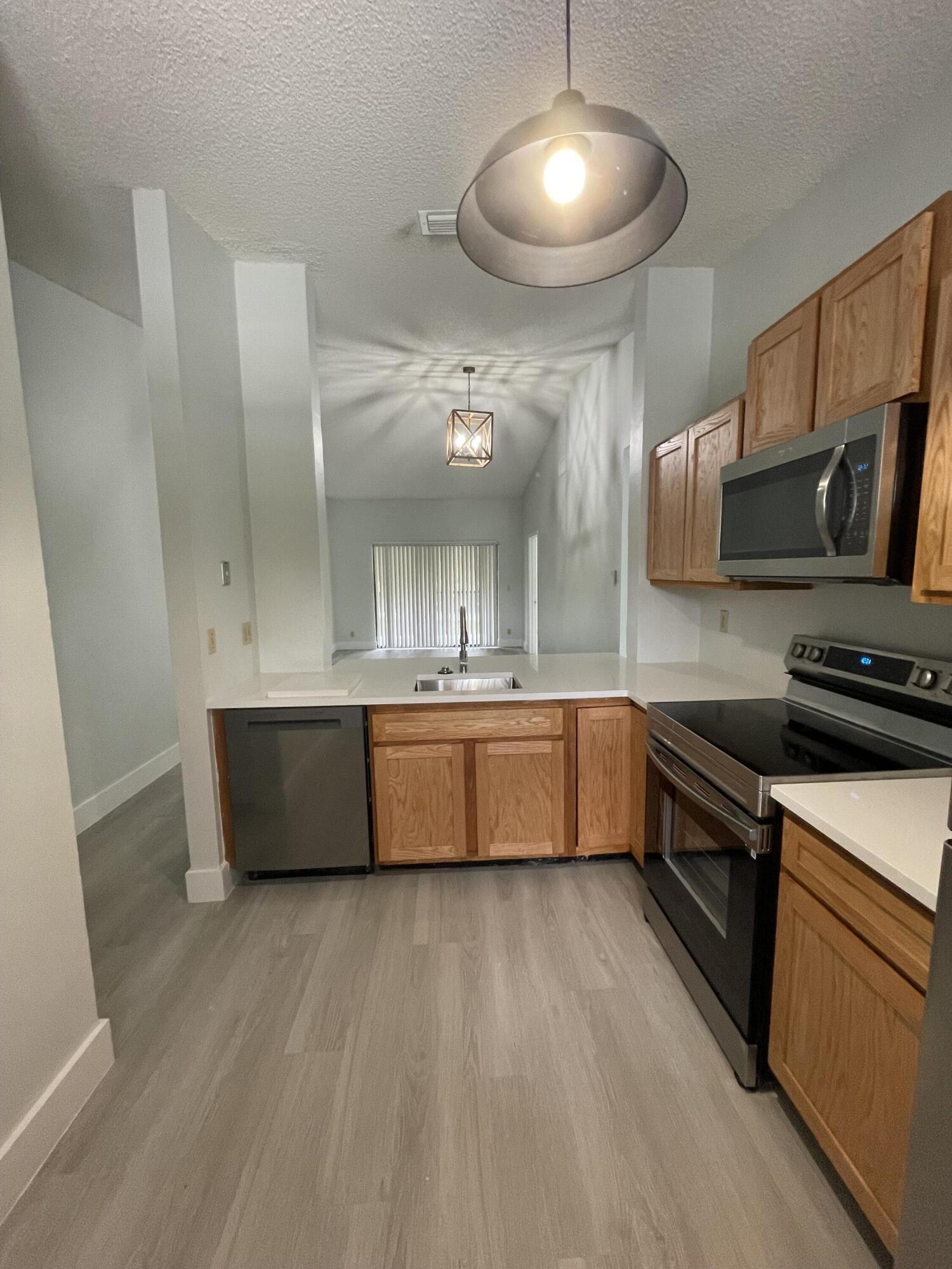 3350 Jaywood Terrace, Unit J221 Boca Raton, FL 33431 - Photo 20 of 31 a large kitchen with stainless steel appliances a large counter top a stove a sink and a refrigerator