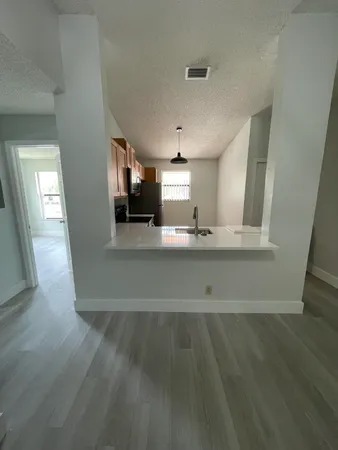 a view of a kitchen with wooden floor and a sink
