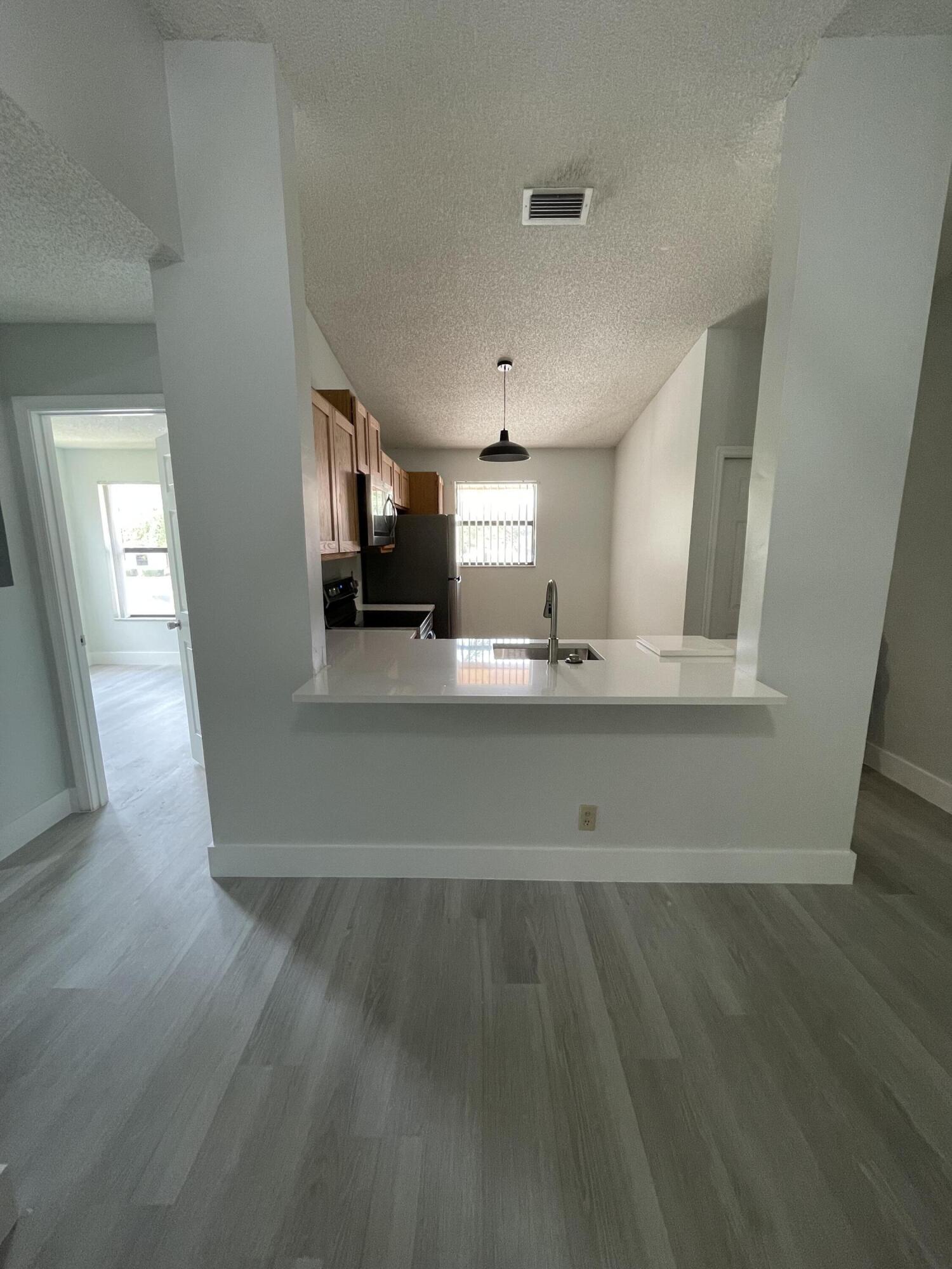 3350 Jaywood Terrace, Unit J221 Boca Raton, FL 33431 - Photo 2 of 31 a view of a kitchen with wooden floor and a sink