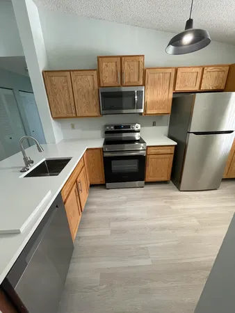 a kitchen with stainless steel appliances a refrigerator and a stove top oven