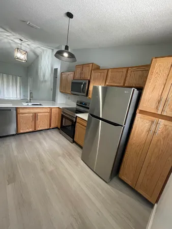 a kitchen with sink refrigerator and microwave
