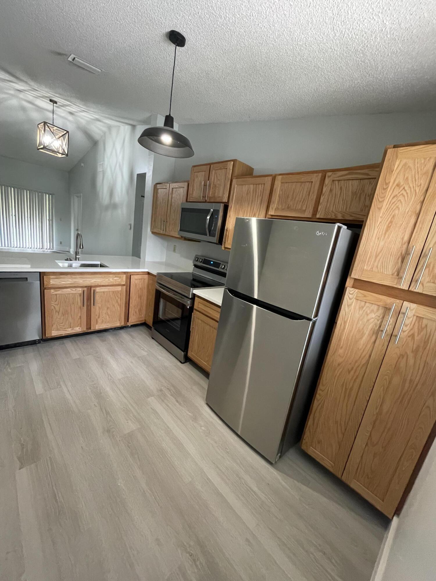 3350 Jaywood Terrace, Unit J221 Boca Raton, FL 33431 - Photo 23 of 31 a kitchen with sink refrigerator and microwave
