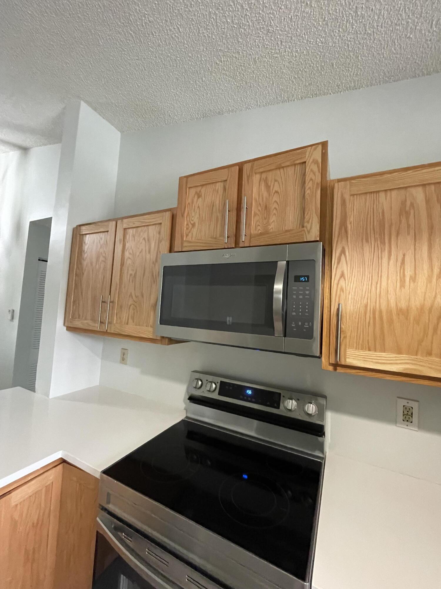 3350 Jaywood Terrace, Unit J221 Boca Raton, FL 33431 - Photo 25 of 31 a kitchen with a stove microwave and sink