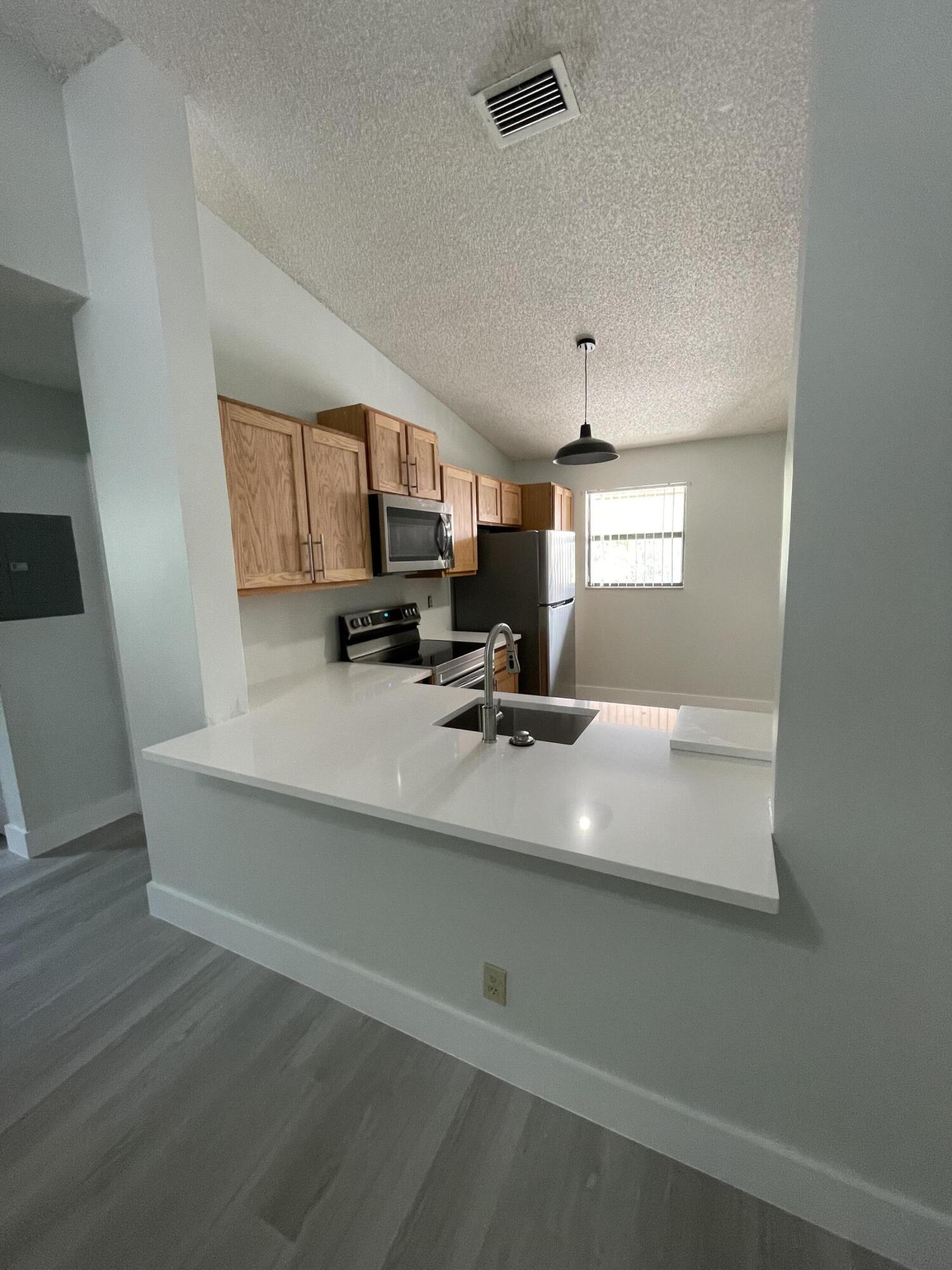 3350 Jaywood Terrace, Unit J221 Boca Raton, FL 33431 - Photo 3 of 31 a view of kitchen with furniture and wooden floor