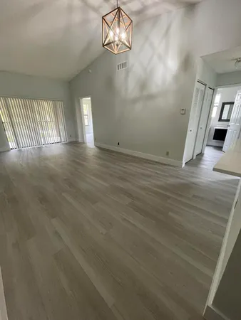 a view of empty room with wooden floor