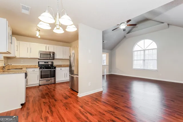 a kitchen with stainless steel appliances granite countertop a refrigerator and a stove top oven