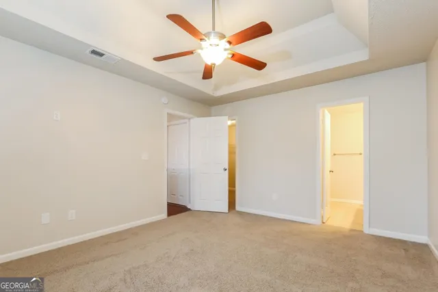 an empty room with ceiling fan and window