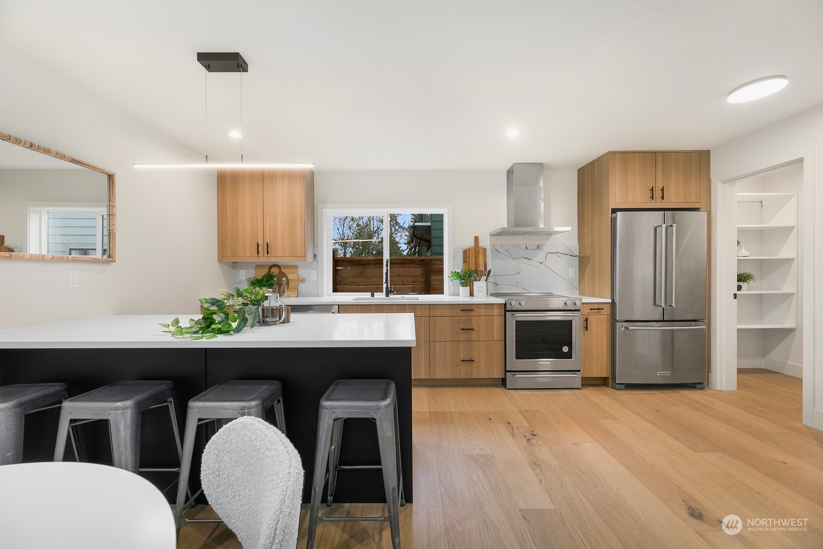 337 Northeast 90th Street, Unit 3 Seattle, WA 98115 - Photo 8 of 20 a kitchen with stainless steel appliances a sink a microwave a refrigerator and wooden floor