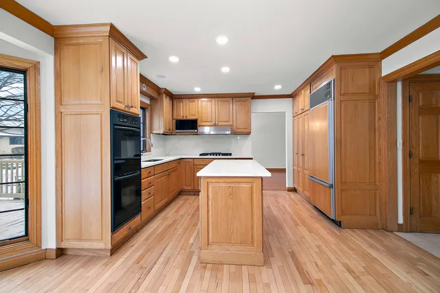 a large kitchen with a large window and stainless steel appliances