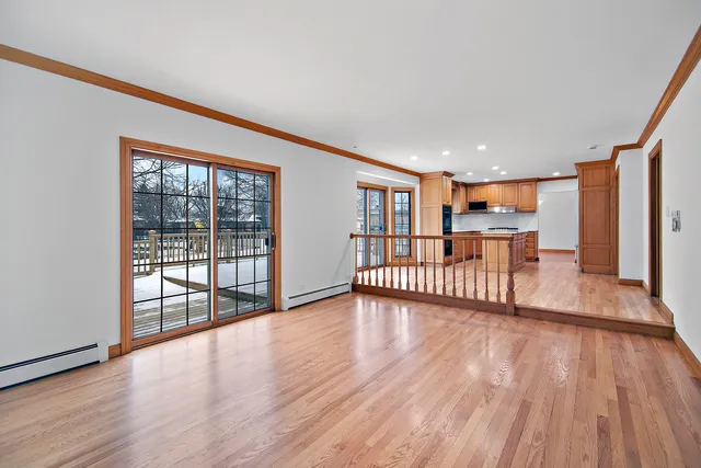 a view of a bedroom with wooden floor and windows
