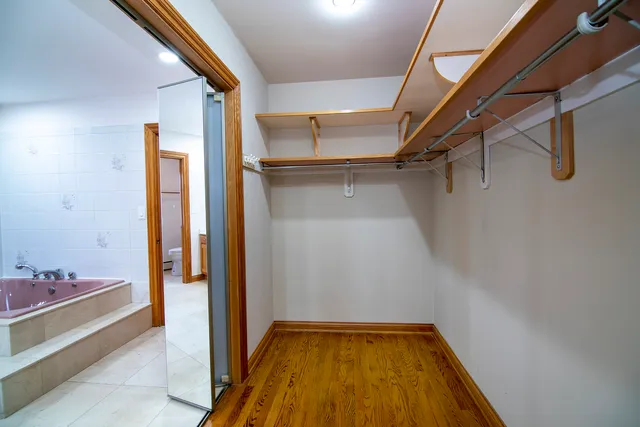 a view of walk in closet with clothes and shoes