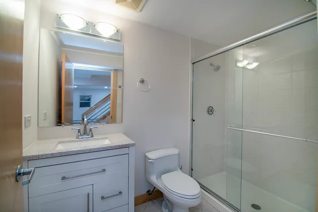 a bathroom with a shower a sink a toilet and mirror