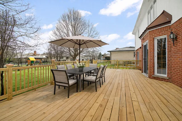a view of a roof deck with table and chairs floor to ceiling window with wooden floor