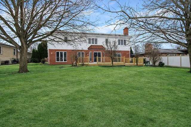 a front view of a house with a yard and trees