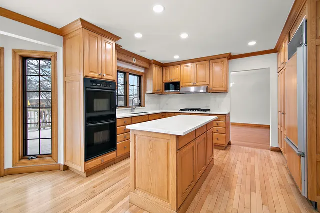 a kitchen with stainless steel appliances granite countertop a refrigerator a sink and a stove