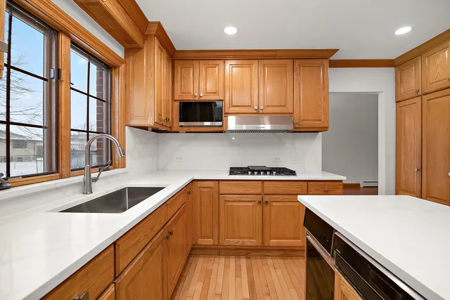a kitchen with stainless steel appliances granite countertop a sink a stove and cabinets