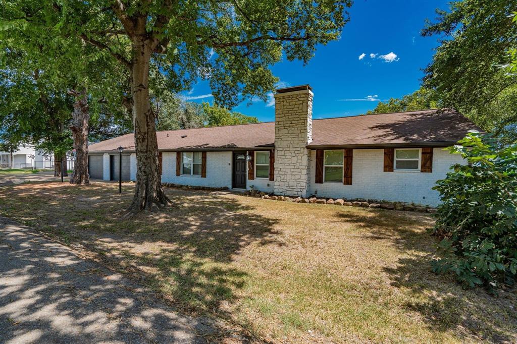 9884 Cherokee Trail Quinlan, TX 75474 - Photo 11 of 36 a backyard of a house with large trees and table and chairs