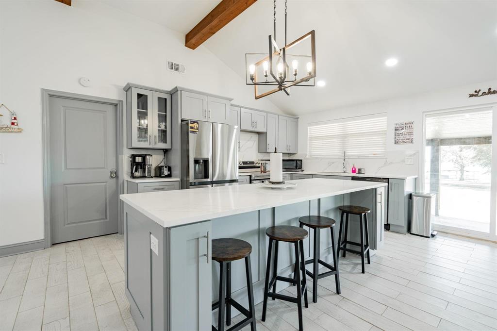 9884 Cherokee Trail Quinlan, TX 75474 - Photo 20 of 36 a kitchen with stainless steel appliances a table chairs and chandelier