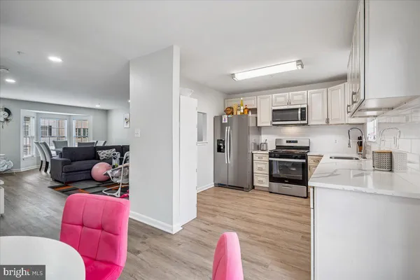 a kitchen with stainless steel appliances kitchen island granite countertop a refrigerator stove top oven and sink