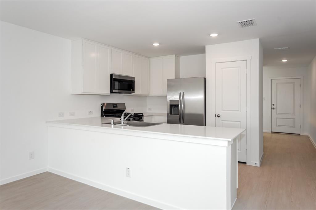 1419 Merlin Blf Street Forney, TX 75126 - Photo 8 of 24 Kitchen featuring white cabinetry, light countertops, a stainless steel sink with a single-handle faucet, a stainless steel gas range with an oven, and a stainless steel refrigerator