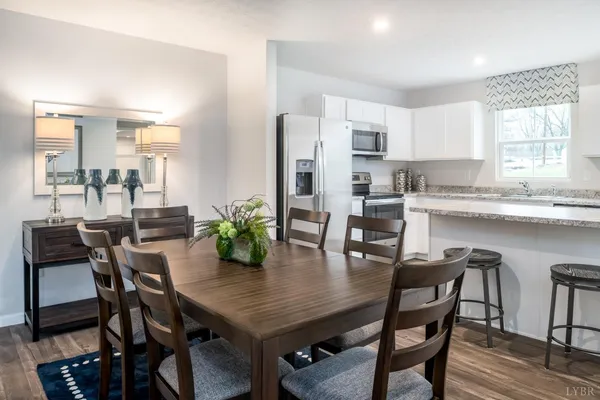 a dining room with stainless steel appliances granite countertop a dining table chairs and view living room