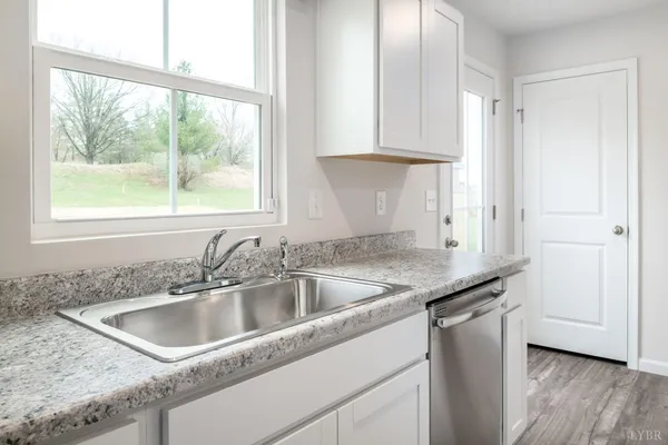 a kitchen with granite countertop a sink and a window