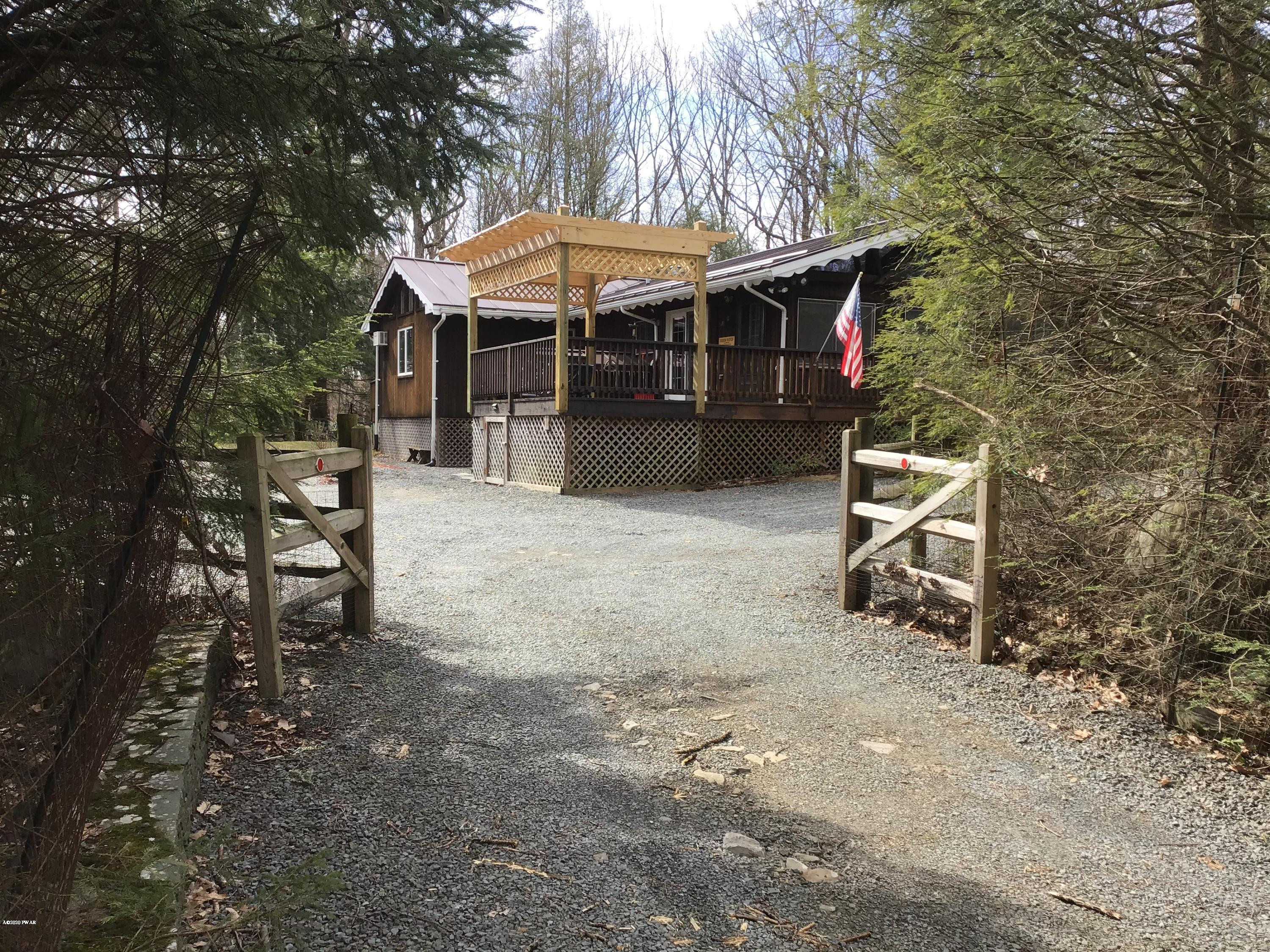 107 Maple Ridge Drive Hawley, PA 18428 - Photo 32 of 32 a patio with a table and chairs under an umbrella