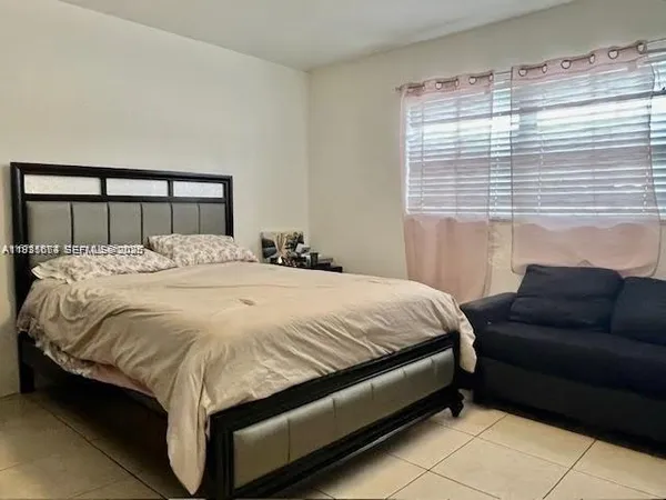 a bedroom with a bed and window