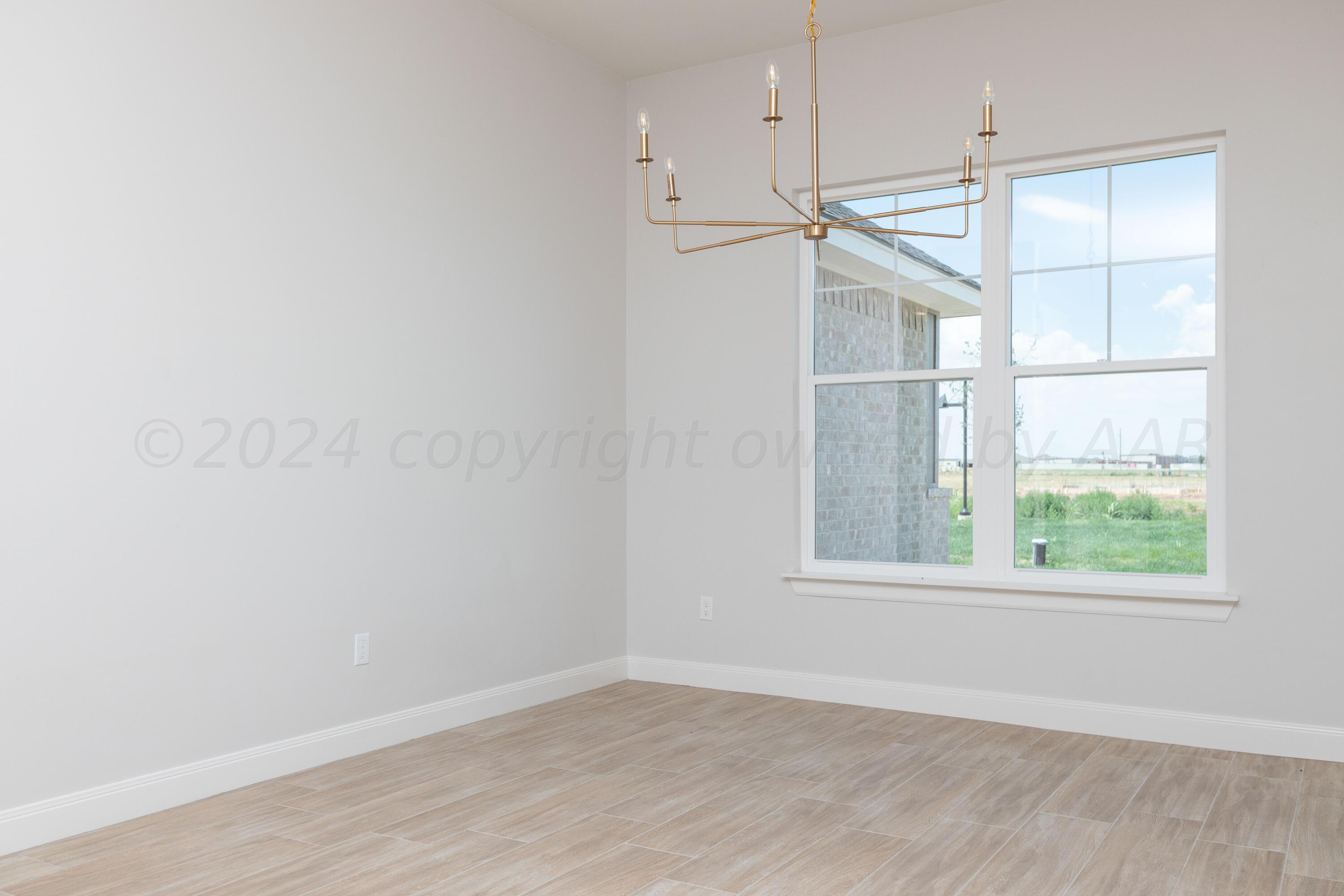 10151 Cactus Flower Road Amarillo, TX 79119 - Photo 11 of 29 an empty room with a window and wooden floor