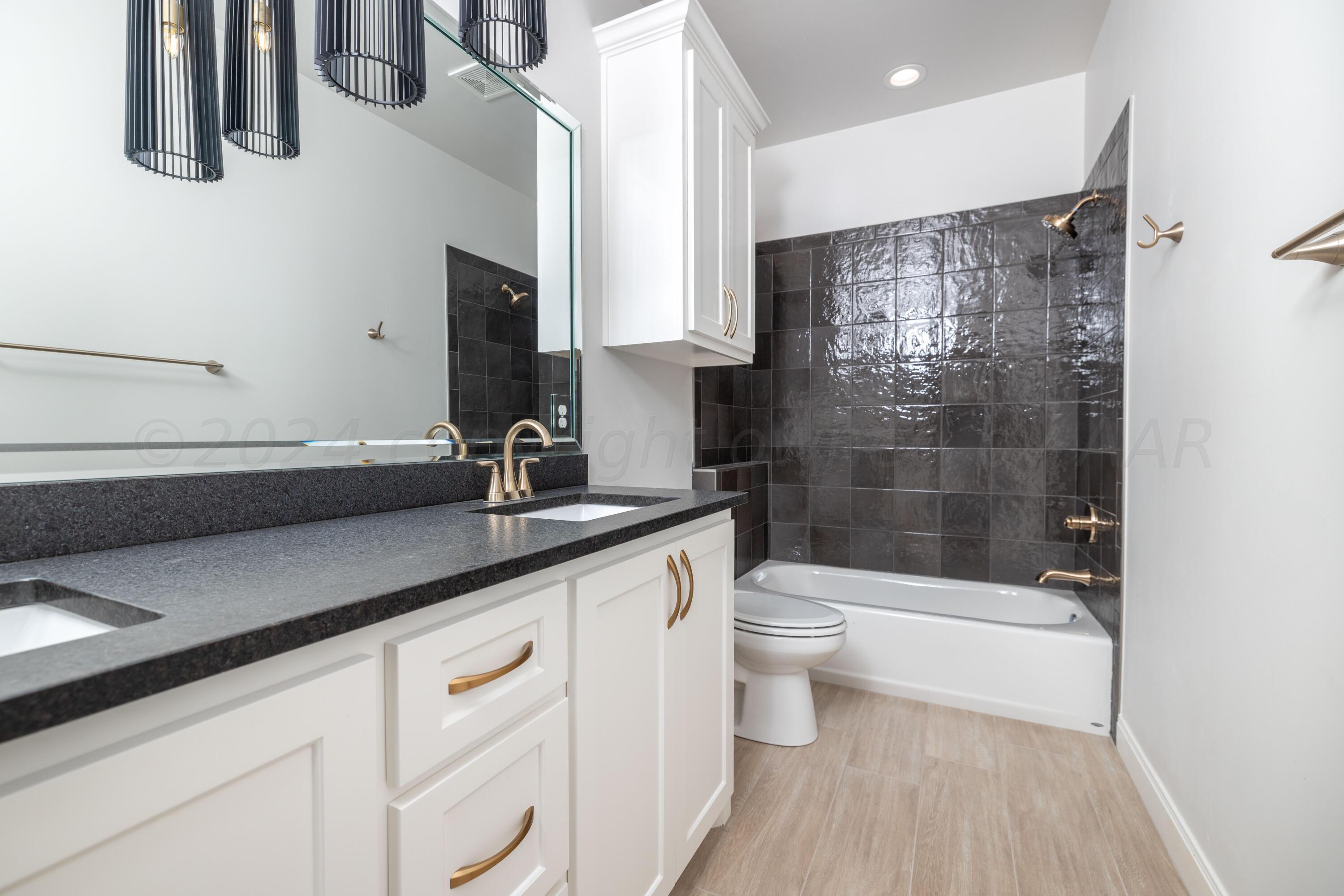 10151 Cactus Flower Road Amarillo, TX 79119 - Photo 22 of 29 a bathroom with a sink a toilet a mirror and shower
