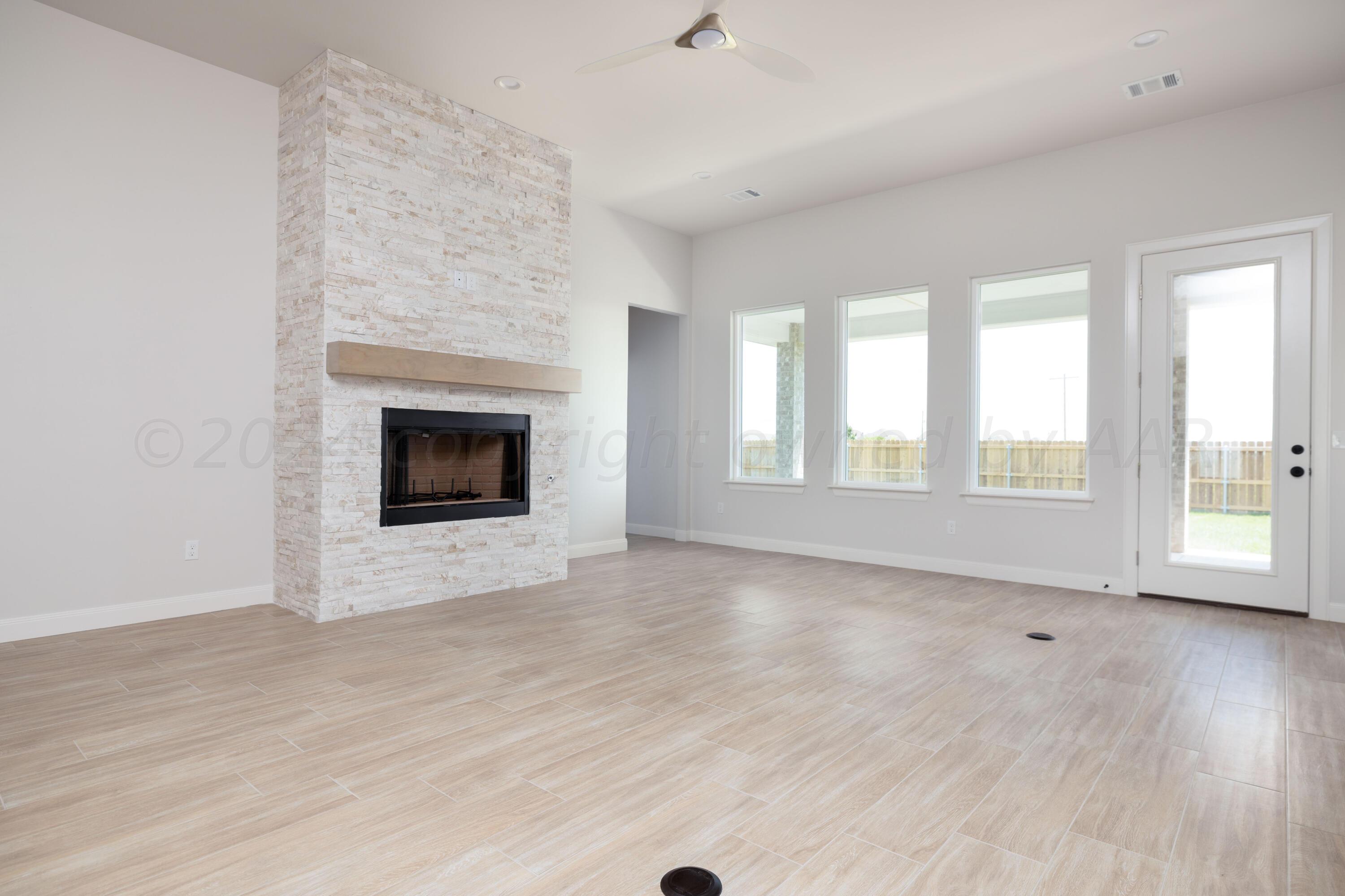 10151 Cactus Flower Road Amarillo, TX 79119 - Photo 8 of 29 a view of an empty room with wooden floor fireplace and a window