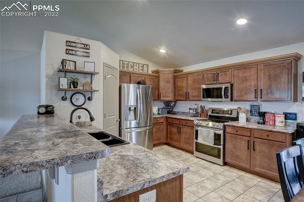 5912 Polly Court Pueblo, CO 81008 - Photo 12 of 40 a kitchen with granite countertop a sink stainless steel appliances and cabinets