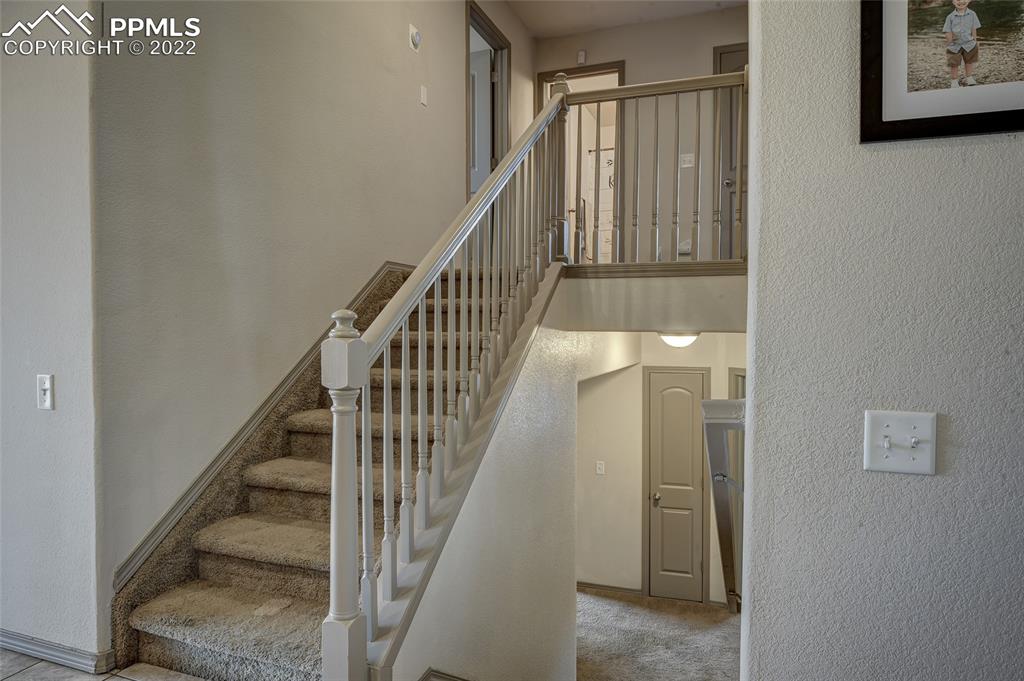 5912 Polly Court Pueblo, CO 81008 - Photo 16 of 40 a view of staircase with lots of frames and walls
