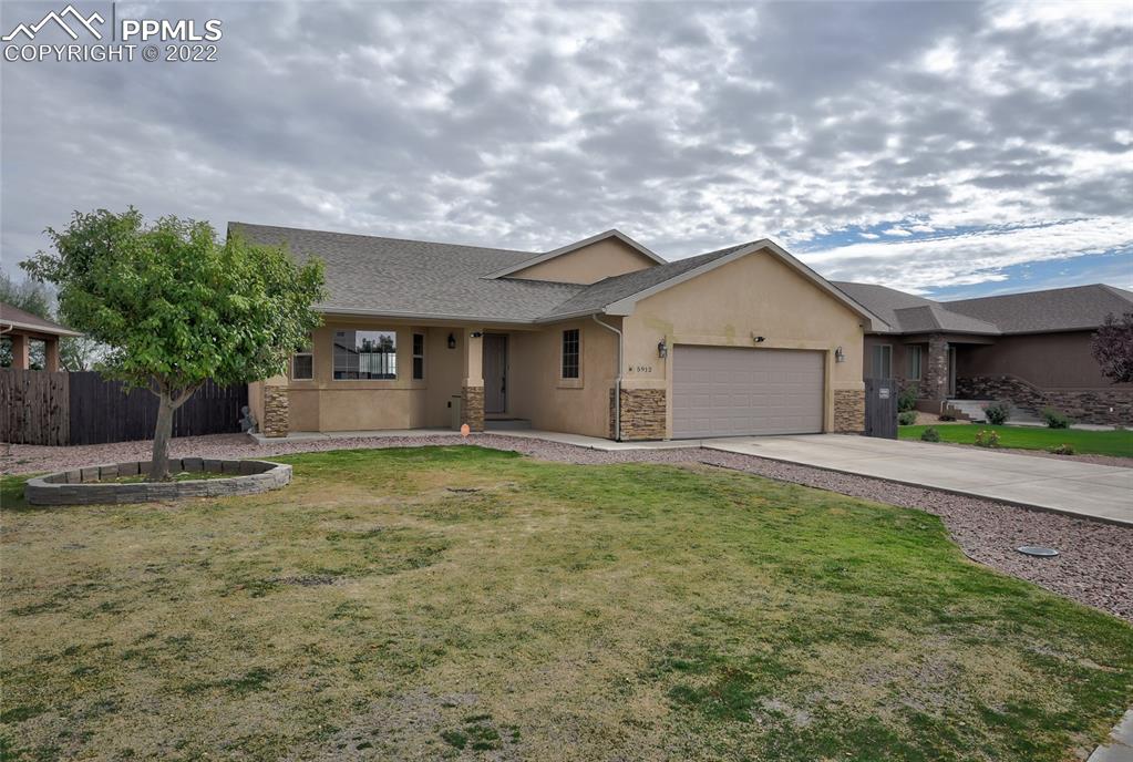 5912 Polly Court Pueblo, CO 81008 - Photo 2 of 40 a view of a house with a yard and garage