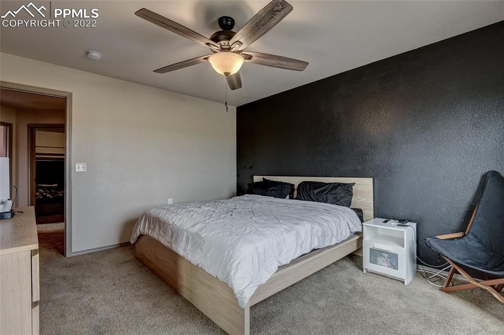 5912 Polly Court Pueblo, CO 81008 - Photo 23 of 40 a spacious bedroom with a bed and a chandelier