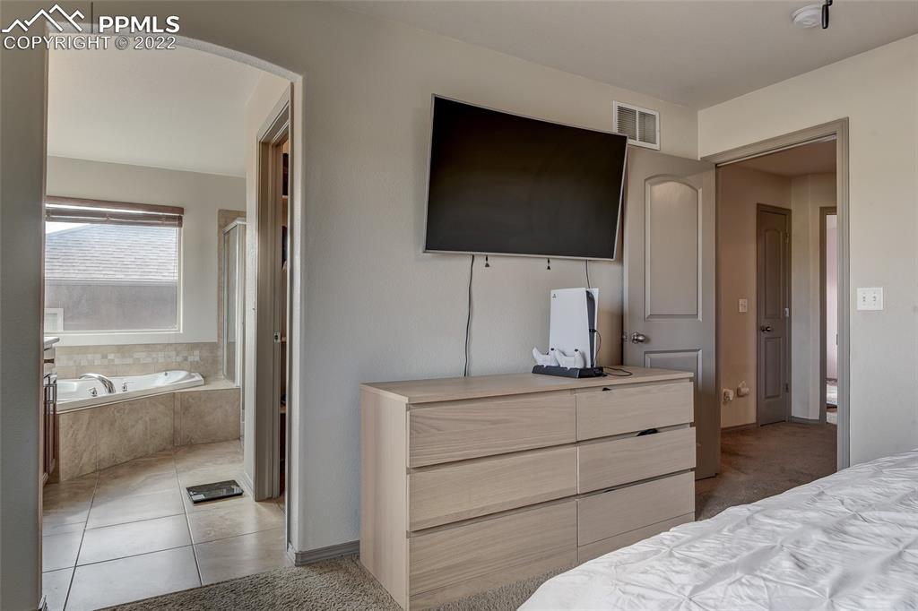 5912 Polly Court Pueblo, CO 81008 - Photo 24 of 40 a bedroom with a bed and a flat screen tv