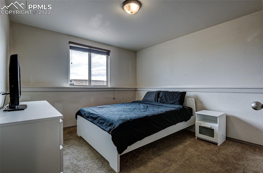 5912 Polly Court Pueblo, CO 81008 - Photo 31 of 40 a bedroom with a bed and a flat tv screen on the dresser