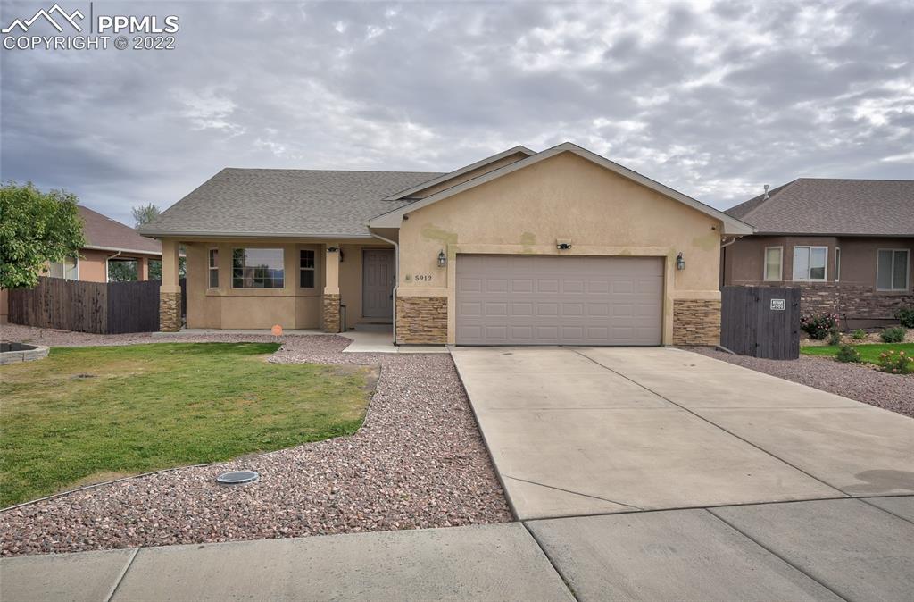 5912 Polly Court Pueblo, CO 81008 - Photo 4 of 40 a view of a house with a yard and a garage