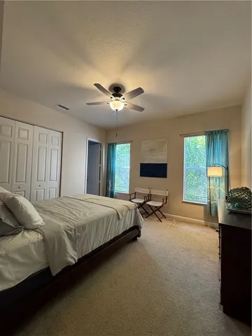 a spacious bedroom with a bed and a chandelier