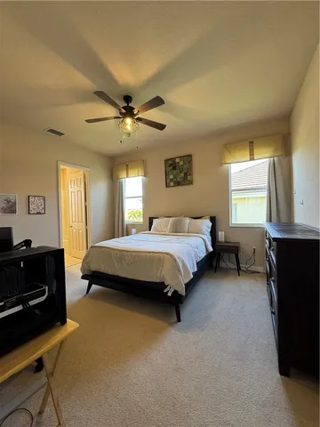 a spacious bedroom with a bed and a chandelier