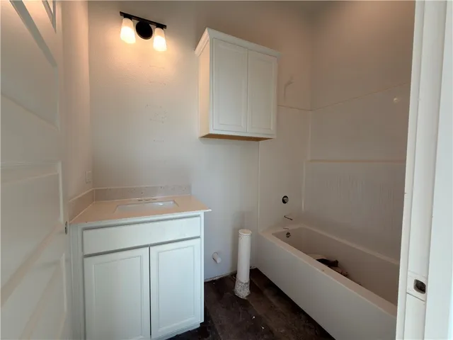 a bathroom with a bathtub sink vanity and toilet