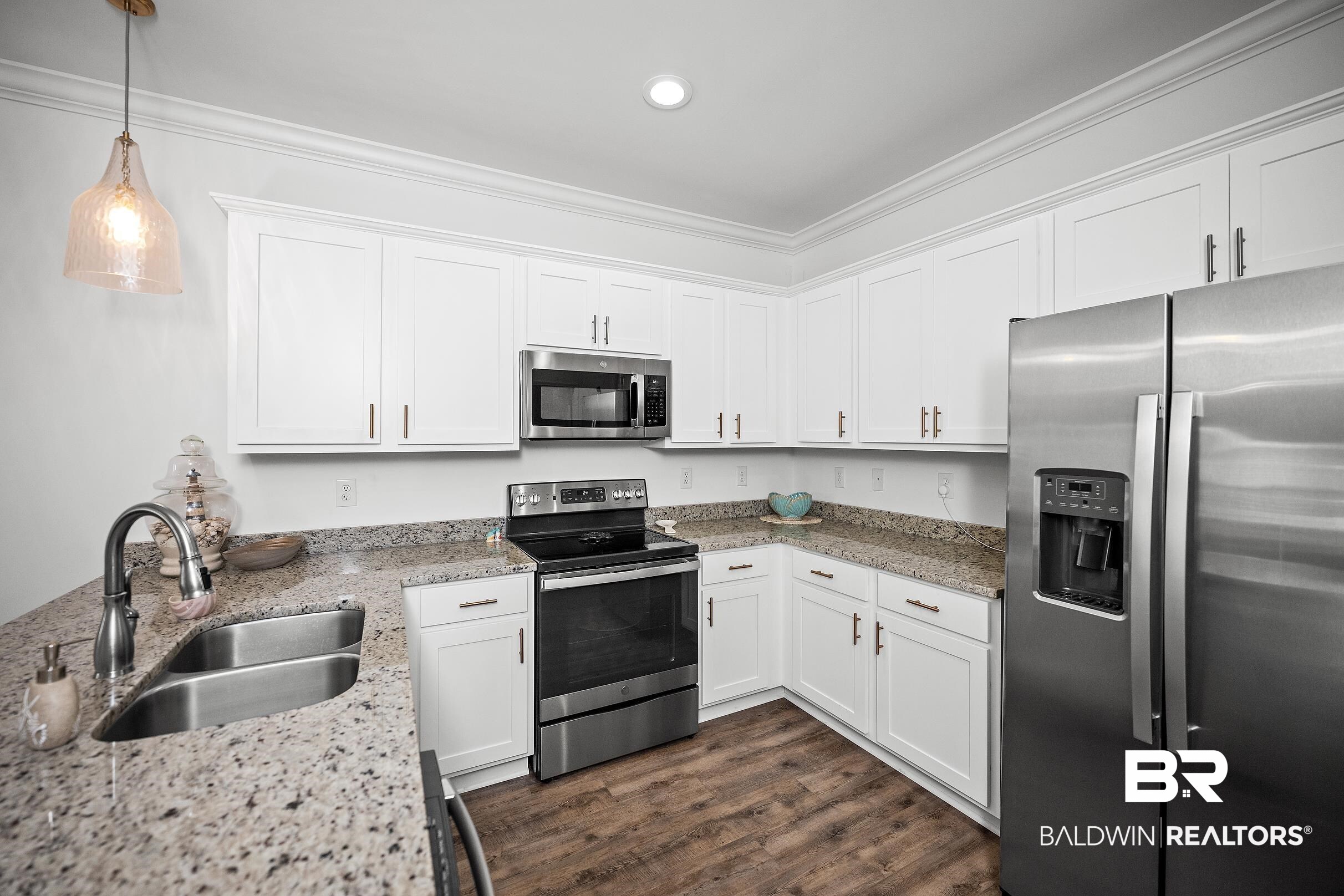 2651 South Juniper Street, Unit 2002 Foley, AL 36535 - Photo 4 of 23 Kitchen featuring white cabinetry, light granite-style countertops, stainless steel appliances, a double basin sink, and wood-finish flooring