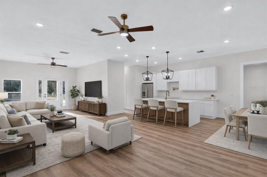 257 Lago Vista Street DeBary, FL 32713 - Photo 12 of 35 a living room with furniture kitchen view and a wooden floor
