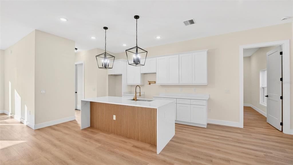 257 Lago Vista Street DeBary, FL 32713 - Photo 13 of 35 a kitchen with kitchen island a sink stainless steel appliances and cabinets