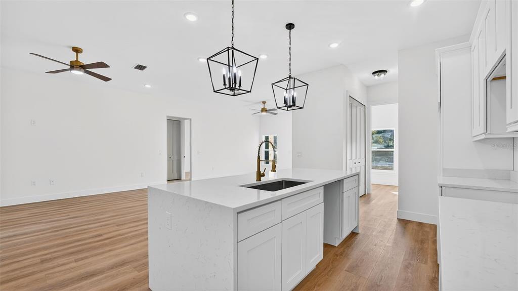 257 Lago Vista Street DeBary, FL 32713 - Photo 16 of 35 a kitchen with stainless steel appliances granite countertop a sink a stove and a wooden floor