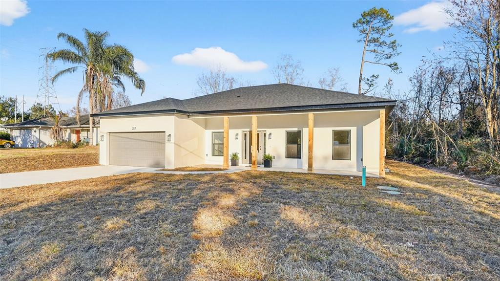 257 Lago Vista Street DeBary, FL 32713 - Photo 3 of 35 a front view of a house with a yard and garage