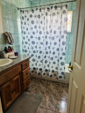 a bathroom with a granite countertop sink a toilet and a shower